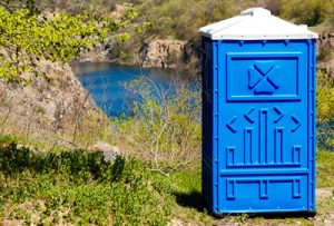 porta potty on a trail next to a river