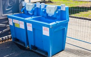 portable hand wash stations next to a chain link fence